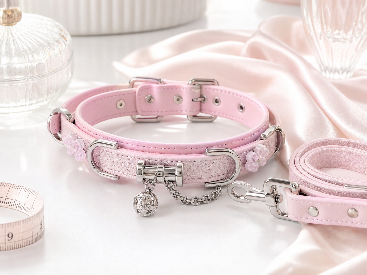 Pink XESODIT BDSM collar with matching leash on white satin