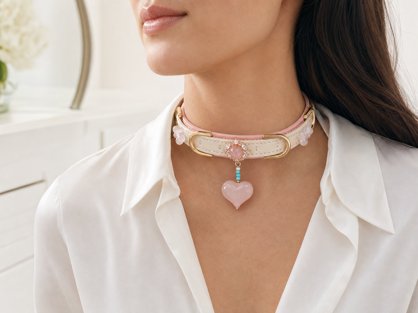 Adult wearing a blush pink XESODIT heart charm collar with gold hardware